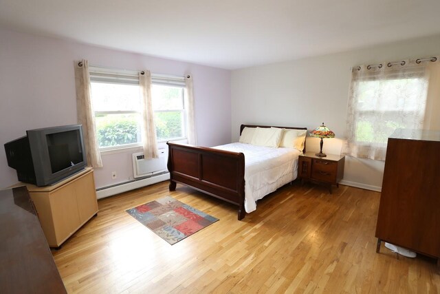 35 Bon Aire Cir Unit 8113, Suffern, NY 10901 - bedroom with baseboard heating, light wood-style flooring, and a wall mounted AC