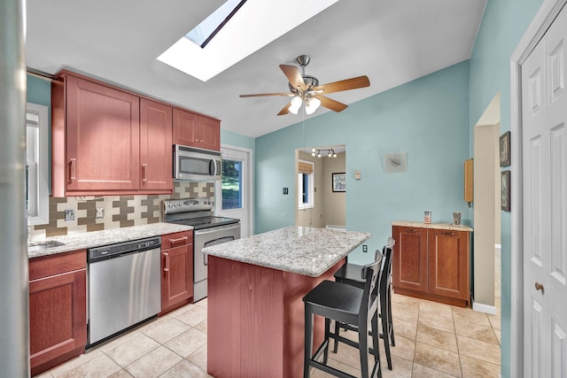 232 County Route 49, Slate Hill, NY 10973 - kitchen featuring stainless steel appliances, backsplash, a skylight, ceiling fan, and a breakfast bar area
