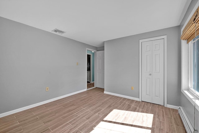232 County Route 49, Slate Hill, NY 10973 - unfurnished bedroom with a baseboard radiator, light wood-style floors, baseboards, and a closet