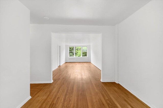 4320 E Van Cortlandt Park E Unit 5E, Bronx, NY 10470 - empty room featuring wood finished floors, baseboards, and a smoke detector