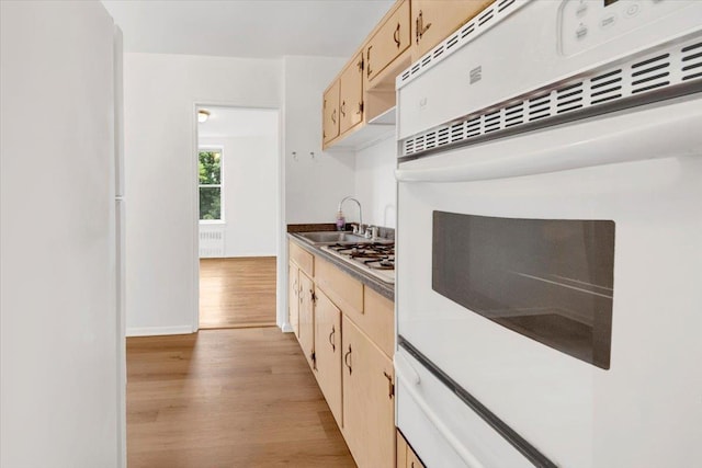 4320 E Van Cortlandt Park E Unit 5E, Bronx, NY 10470 - kitchen with white oven, light wood finished floors, a sink, radiator heating unit, and light brown cabinetry