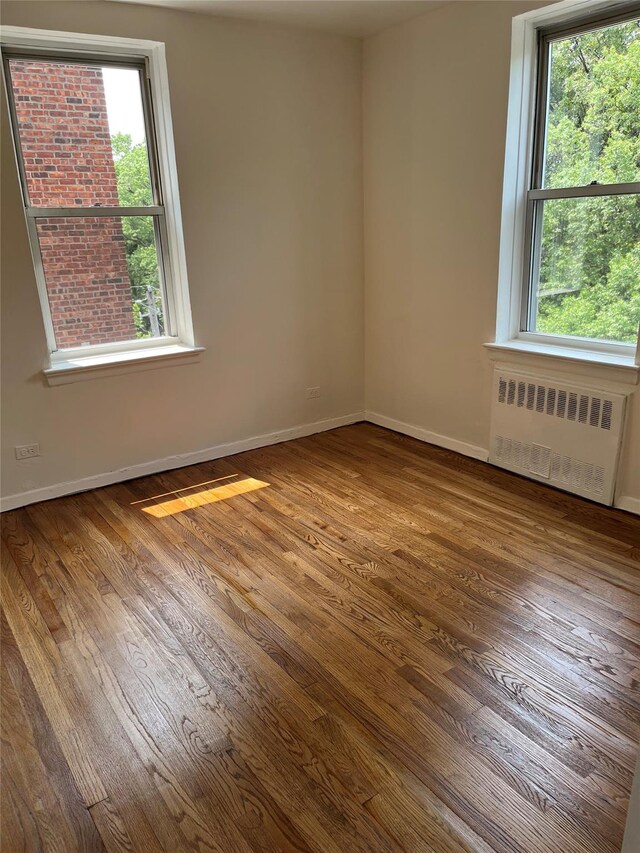 4320 E Van Cortlandt Park E Unit 5E, Bronx, NY 10470 - unfurnished room featuring radiator, healthy amount of natural light, and dark wood-type flooring