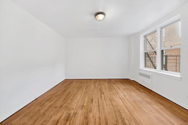 4320 E Van Cortlandt Park E Unit 5E, Bronx, NY 10470 - empty room with radiator, wood finished floors, and baseboards