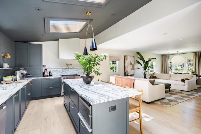 350 Skunk Ln, Cutchogue, NY 11935 - kitchen featuring light wood finished floors, a breakfast bar, open floor plan, and a kitchen island