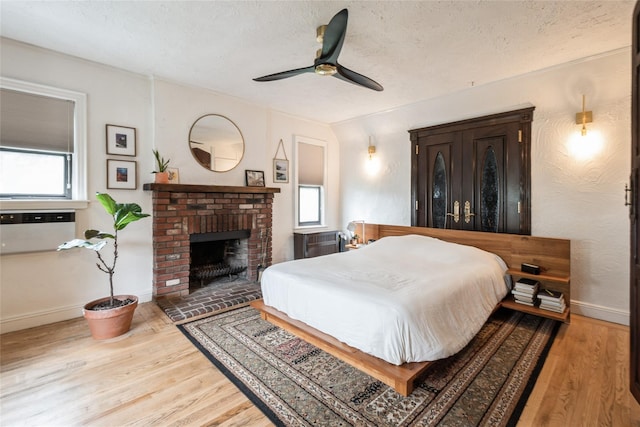 25 Cliffside Dr, Yonkers, NY 10710 - bedroom with wood finished floors, a textured ceiling, a brick fireplace, and a ceiling fan