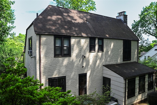 25 Cliffside Dr, Yonkers, NY 10710 - back of house with stucco siding, roof with shingles, and a chimney