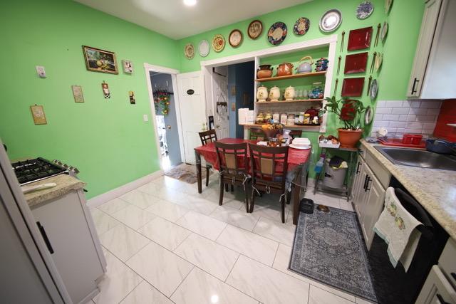 228 N 5th Ave, Mount Vernon, NY 10550 - kitchen with a sink, light countertops, backsplash, and black dishwasher
