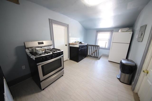 228 N 5th Ave, Mount Vernon, NY 10550 - kitchen with stainless steel gas range oven, freestanding refrigerator, lofted ceiling, light countertops, and dark cabinets