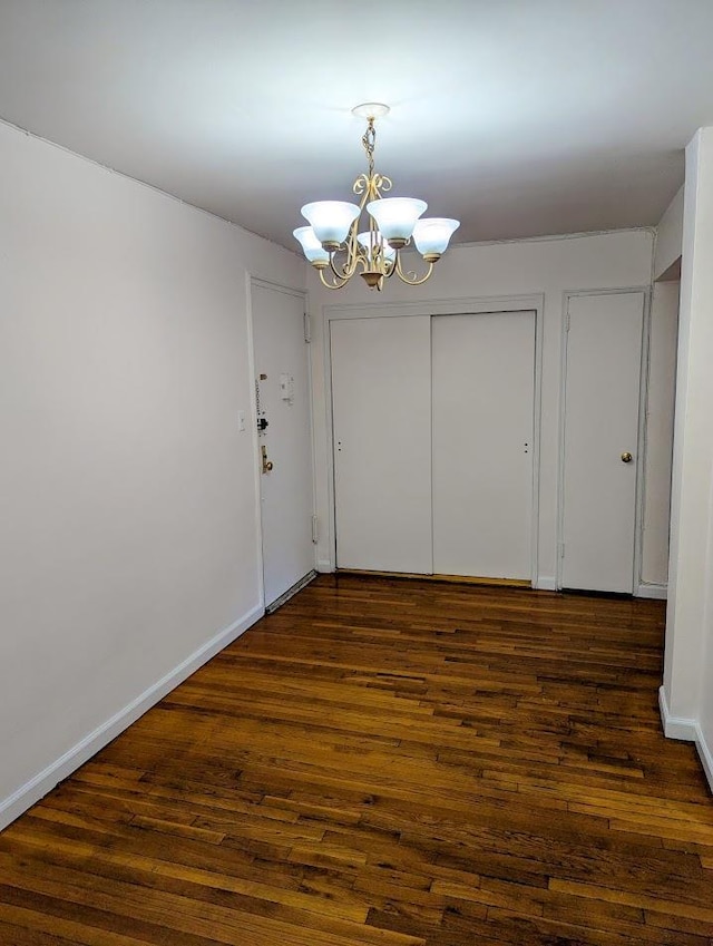 94-31 59th Ave Unit 4B, Elmhurst, NY 11373 - unfurnished dining area featuring a chandelier, dark wood-style floors, and baseboards