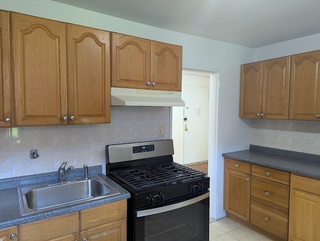 94-31 59th Ave Unit 4B, Elmhurst, NY 11373 - kitchen with under cabinet range hood, stainless steel gas range, a sink, dark countertops, and tasteful backsplash