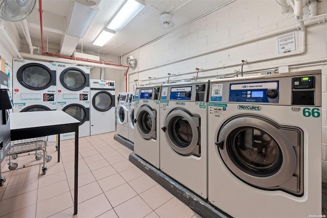 94-31 59th Ave Unit 4B, Elmhurst, NY 11373 - community laundry room with stacked washer and clothes dryer, independent washer and dryer, concrete block wall, and light tile patterned floors
