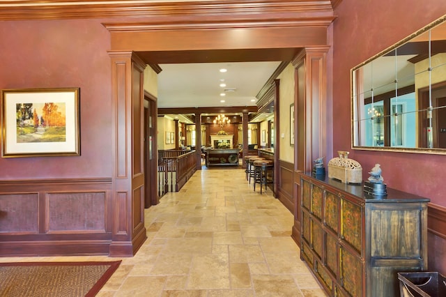 55 Westgate Rd, Muttontown, NY 11791 - corridor featuring stone tile flooring, ornamental molding, a decorative wall, and wainscoting