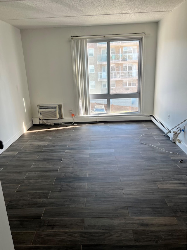 397 N Broadway Unit 3E, Yonkers, NY 10701 - empty room featuring dark wood finished floors, a wall unit AC, baseboards, and a textured ceiling