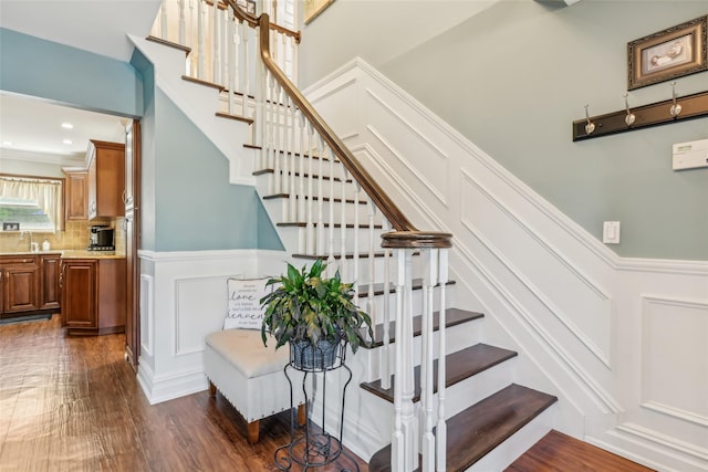 26 Wilson St, Port Jefferson Station, NY 11776 - stairs featuring a decorative wall, wood finished floors, and wainscoting