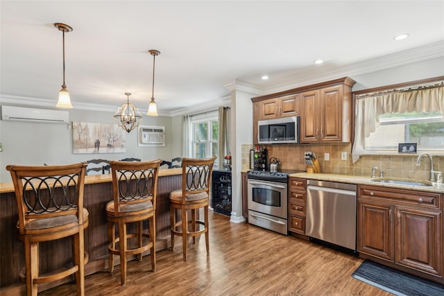 26 Wilson St, Port Jefferson Station, NY 11776 - kitchen with appliances with stainless steel finishes, a wall mounted AC, a sink, a breakfast bar, and crown molding