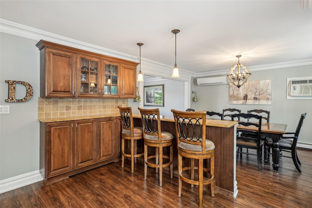 26 Wilson St, Port Jefferson Station, NY 11776 - bar area featuring an AC wall unit, dark wood finished floors, crown molding, hanging light fixtures, and decorative backsplash