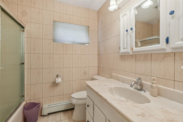 26 Wilson St, Port Jefferson Station, NY 11776 - full bathroom featuring tile walls, a baseboard radiator, toilet, vanity, and tile patterned floors