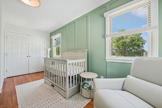 2660 Rosebud Ave, Merrick, NY 11566 - bedroom with a decorative wall, light wood finished floors, a closet, and a crib