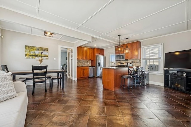 2660 Rosebud Ave, Merrick, NY 11566 - kitchen featuring appliances with stainless steel finishes, brown cabinetry, backsplash, a peninsula, and ornamental molding