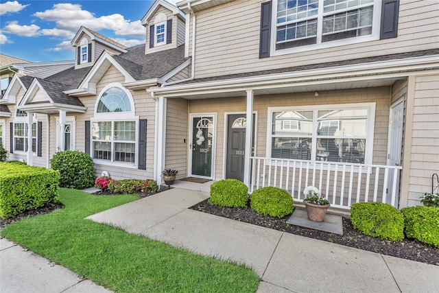 1011 Willow Ln, Valley Stream, NY 11580 - view of exterior entry featuring roof with shingles and a porch