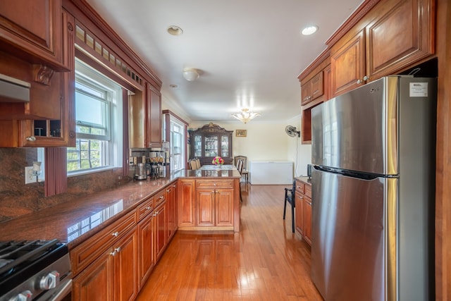 580 Valley Ave, Yonkers, NY 10703 - kitchen featuring stainless steel appliances, a peninsula, brown cabinets, crown molding, and light wood-type flooring