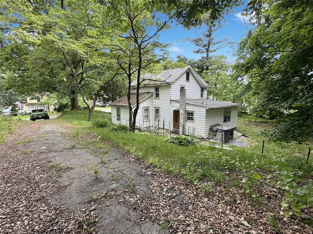 9 Church St, Hyde Park, NY 12538 - view of side of property featuring roof with shingles, cooling unit, and view of wooded area