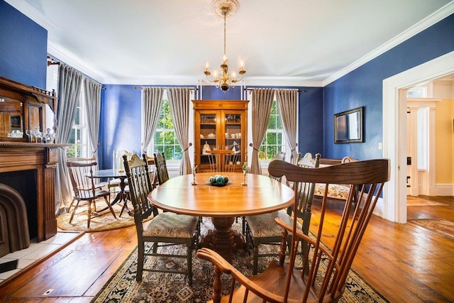 9 Ireland Ave, Wappingers Falls, NY 12590 - dining area featuring light wood finished floors, a chandelier, crown molding, and a fireplace