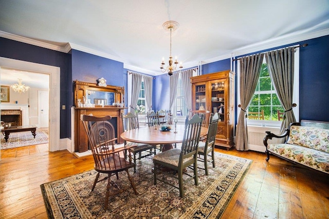 9 Ireland Ave, Wappingers Falls, NY 12590 - dining room with a chandelier, crown molding, a brick fireplace, hardwood / wood-style flooring, and baseboards