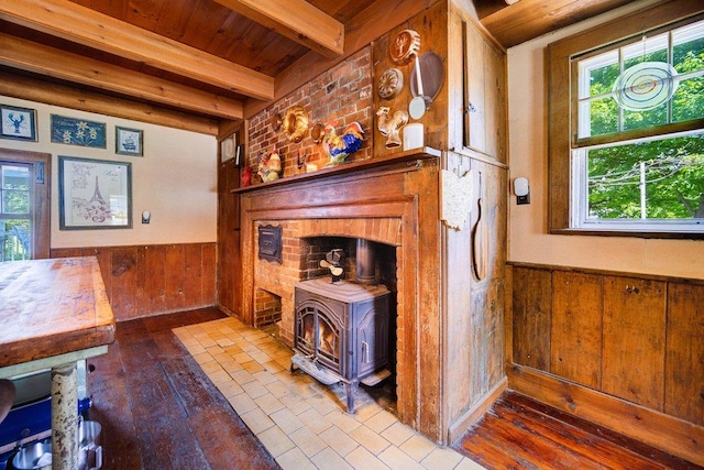 9 Ireland Ave, Wappingers Falls, NY 12590 - detailed view of a wood stove, wood ceiling with exposed beams, a wainscoted wall, wooden walls, and wood finished floors