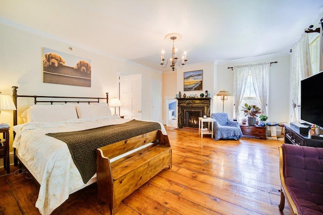9 Ireland Ave, Wappingers Falls, NY 12590 - bedroom featuring crown molding, hardwood / wood-style flooring, a chandelier, and a fireplace with flush hearth