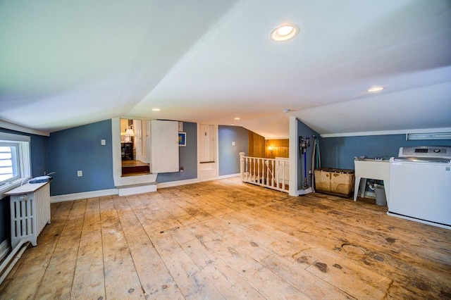 9 Ireland Ave, Wappingers Falls, NY 12590 - unfurnished living room with washer / dryer, vaulted ceiling, hardwood / wood-style flooring, baseboards, and recessed lighting
