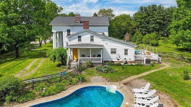 9 Ireland Ave, Wappingers Falls, NY 12590 - rear view of property featuring a chimney, an outdoor pool, cooling unit, and covered porch