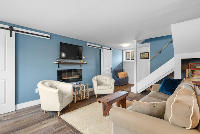 285 County Road 20, Cairo, NY 12413 - living room with a barn door, stairway, wood finished floors, baseboards, and a glass covered fireplace