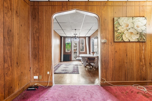 712 E 40th St, Brooklyn, NY 11210 - carpeted foyer with baseboards, wooden walls, a drop ceiling, and wood finished floors