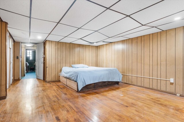 712 E 40th St, Brooklyn, NY 11210 - bedroom featuring a drop ceiling, hardwood / wood-style flooring, and wood walls