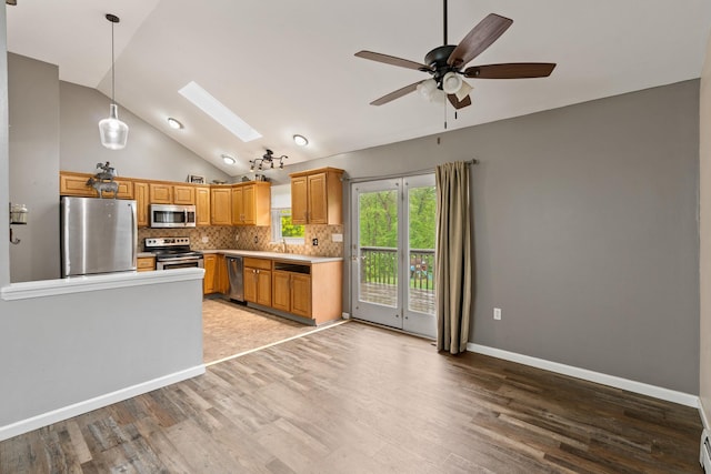 22 Rosio Ln, Modena, NY 12548 - kitchen featuring appliances with stainless steel finishes, a skylight, lofted ceiling, light wood-style flooring, and decorative backsplash