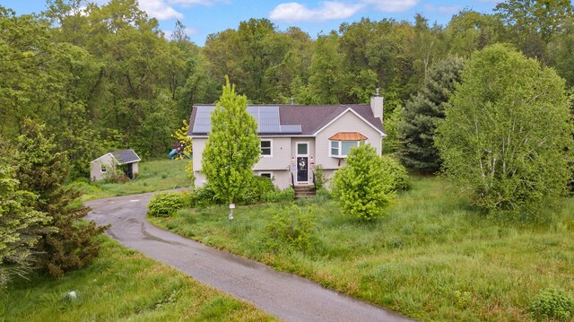 22 Rosio Ln, Modena, NY 12548 - view of front of house featuring solar panels, a chimney, a view of trees, and asphalt driveway