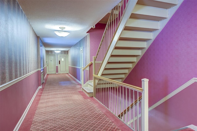 2 Town House Pl Unit 2H, Great Neck, NY 11021 - hallway featuring carpet floors, stairway, baseboards, and a textured ceiling