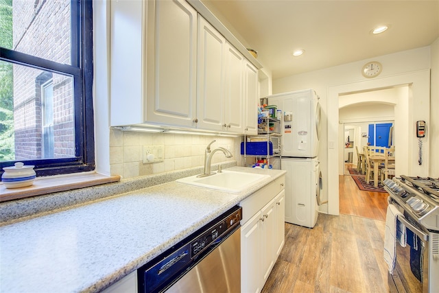 2 Town House Pl Unit 2H, Great Neck, NY 11021 - kitchen with stainless steel appliances, stacked washer / drying machine, a sink, healthy amount of natural light, and recessed lighting