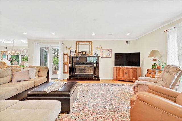 249 Park Ave, Eastchester, NY 10709 - living room featuring a chandelier, ornamental molding, a glass covered fireplace, recessed lighting, and wood finished floors