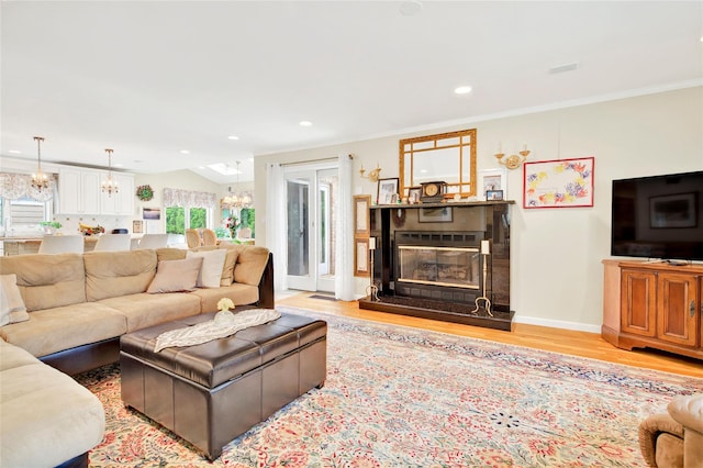 249 Park Ave, Eastchester, NY 10709 - living area with a chandelier, light wood finished floors, a glass covered fireplace, recessed lighting, and crown molding