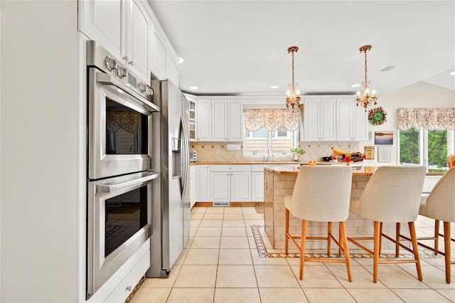 249 Park Ave, Eastchester, NY 10709 - kitchen with stainless steel appliances, healthy amount of natural light, backsplash, a breakfast bar, and recessed lighting