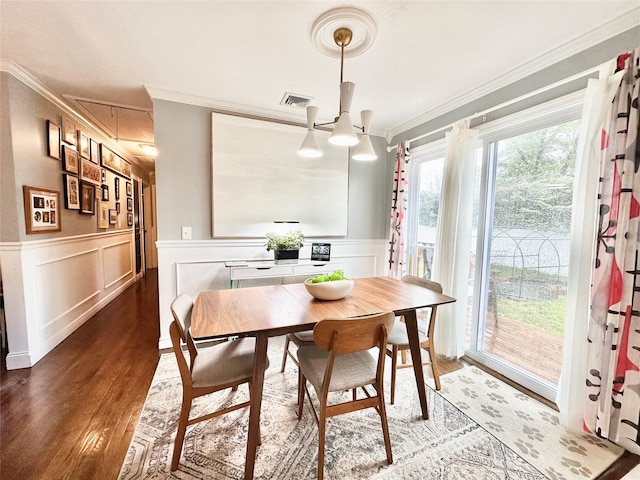 165 Smith Ave, Holbrook, NY 11741 - dining space with ornamental molding, attic access, wood finished floors, a chandelier, and a wainscoted wall