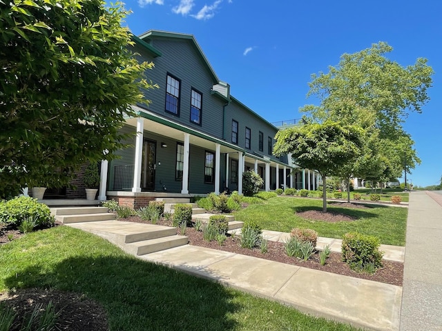 back of property with a porch and a yard