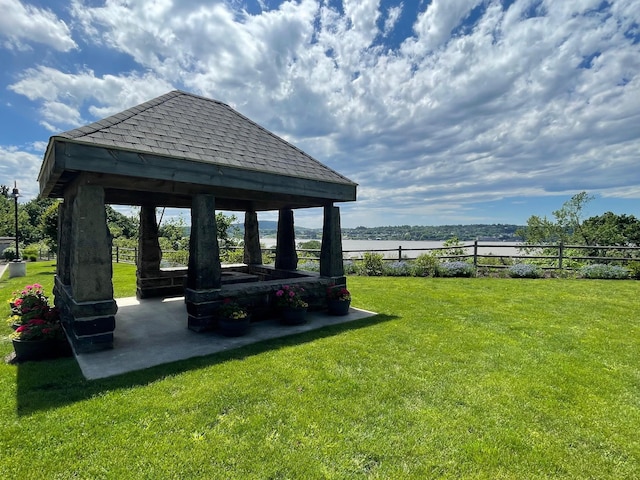 surrounding community with a gazebo, a water view, and a patio area