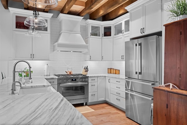 17 River Ridge Court, Beacon, NY 12508 - kitchen with stainless steel appliances, a sink, custom exhaust hood, light wood-type flooring, and decorative backsplash