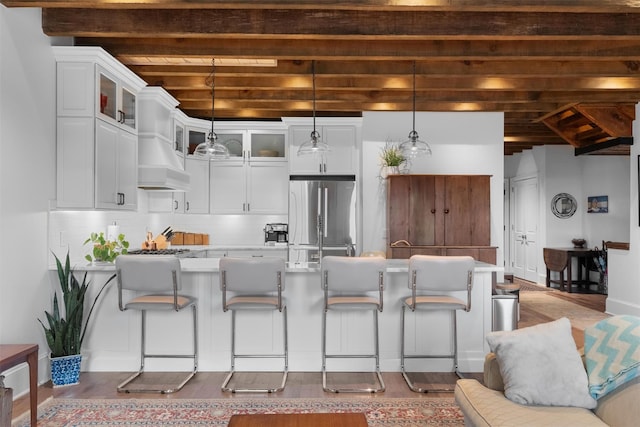 17 River Ridge Court, Beacon, NY 12508 - kitchen featuring freestanding refrigerator, beam ceiling, wood finished floors, backsplash, and glass insert cabinets