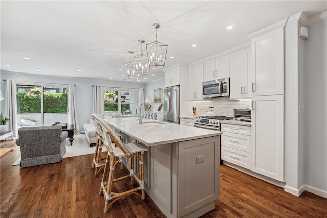 216 Purchase St Unit A, Rye, NY 10580 - kitchen featuring stainless steel appliances, a sink, a kitchen island with sink, white cabinets, and recessed lighting