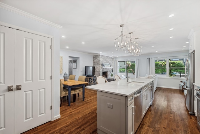 216 Purchase St Unit A, Rye, NY 10580 - kitchen featuring a sink, gray cabinetry, a brick fireplace, ornamental molding, and stainless steel appliances