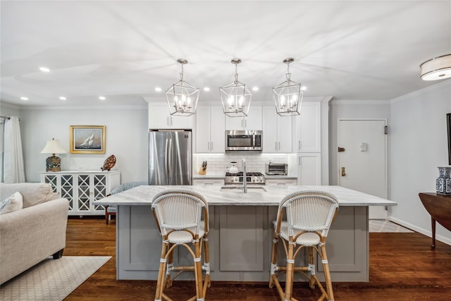 216 Purchase St Unit A, Rye, NY 10580 - kitchen featuring stainless steel appliances, backsplash, a sink, ornamental molding, and a kitchen bar